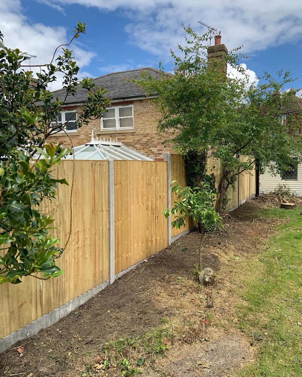 This is a photo of fence panels installed in a residential garden using concrete posts and gravel boards. Installed by Fast Fix Fencing Oxted